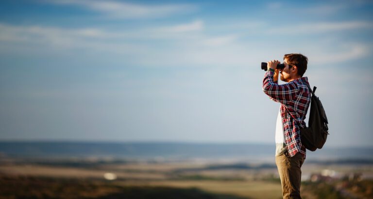 Guy,Looking,At,Binoculars,In,Hill.,Man,In,T-shirt,With